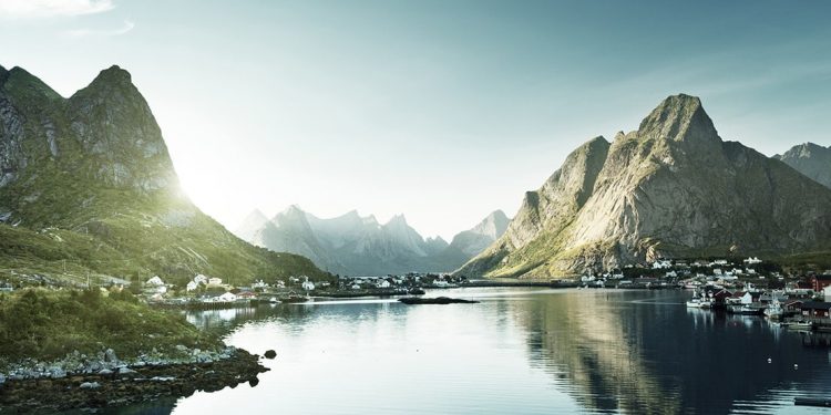 Mountains rise up on either side of a river in Norway