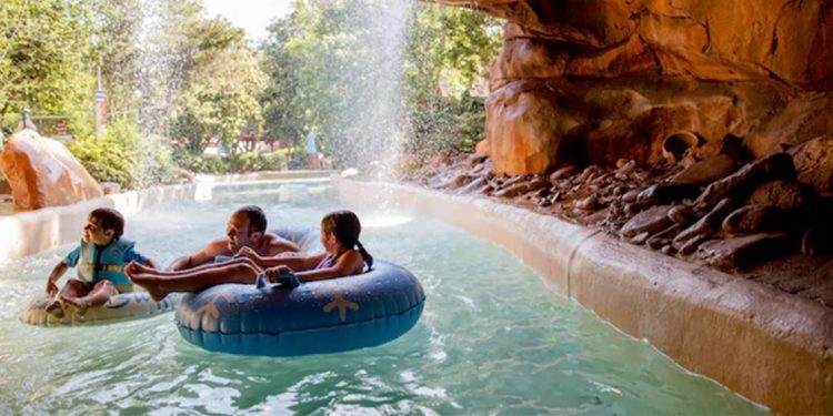 A family of three is water tubing down large lazy river