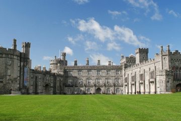 A large castle with numerous buildings includes large towers and three stories