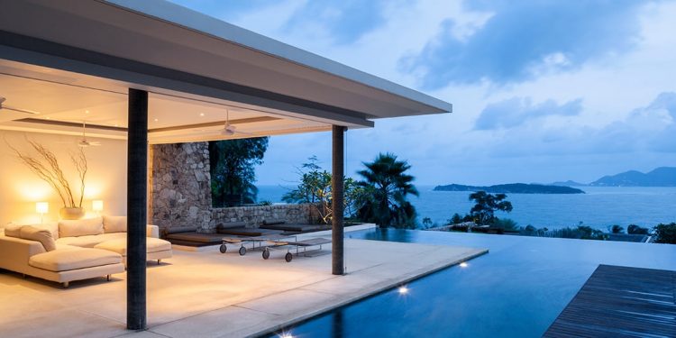 A luxurious hotel includes an outdoor sofa with a patio and private pool with a view of the ocean