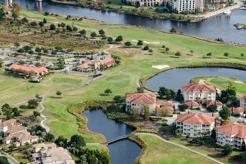 California homes with white stucco and red roofs sit close-by a South Carolina golf course surrounded by rivers and small ponds of water