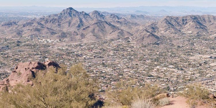 A photo of an Arizona city is taken from a small mountain in Piestewa Park during the day