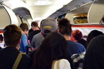A group of people is preparing to get off of their plane ride