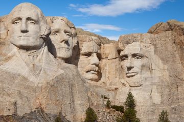 Four faces of presidents carved into rock face.