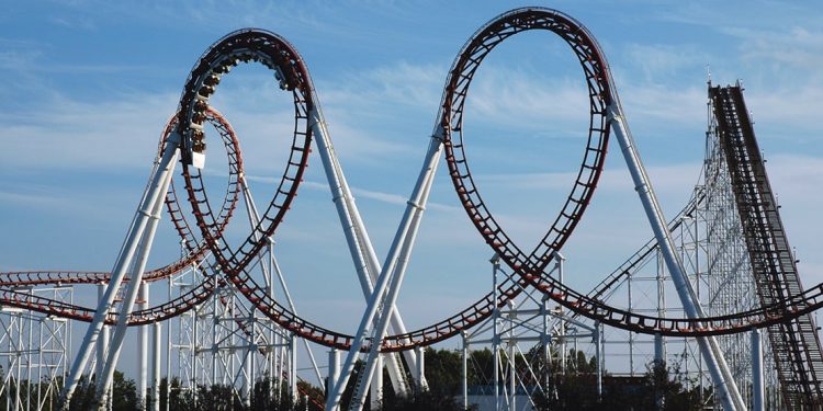 A group of people ride a rollercoaster with two extreme loops back-to-back