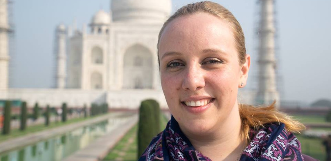Smiling face of woman out front of Taj Mahal.