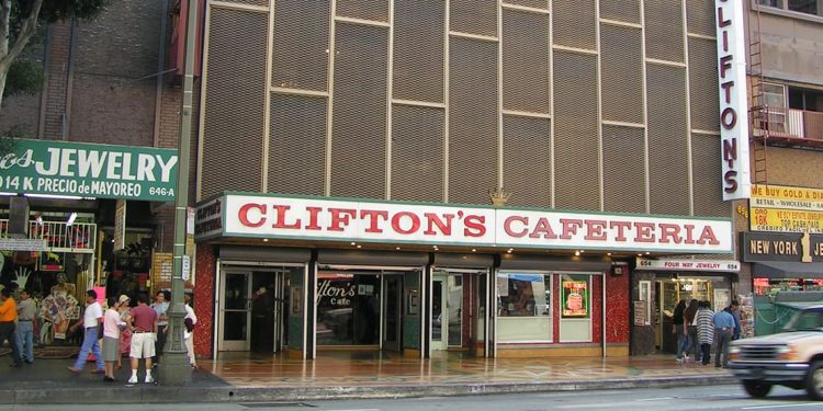 Outside of restaurant with white sign and red lettering. Brown exterior extending upwards.