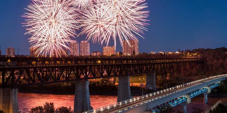 Fireworks over a high level train bridge with highway bridge in foreground.