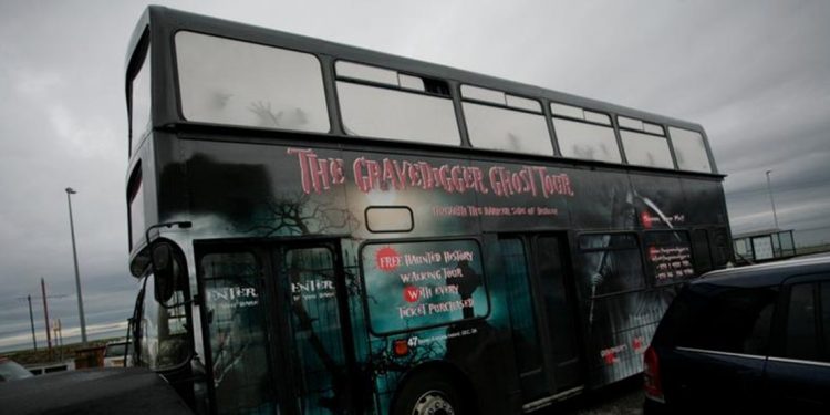 Black doubledecker bus with "The Gravedigger Ghost Tour" on the side in red lettering.