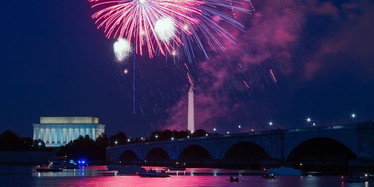Fireworks over the water with boats floating down below. Lincoln Memorial and Washington Monument are in the background.