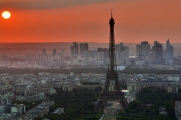 Orange sunset over Paris with Eiffel Tower in the foreground.