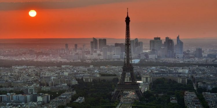 Orange sunset over Paris with Eiffel Tower in the foreground.