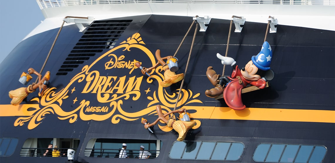 The back of a Disney cruise ship with Mickey and the brooms from Fantasia hanging off the back.