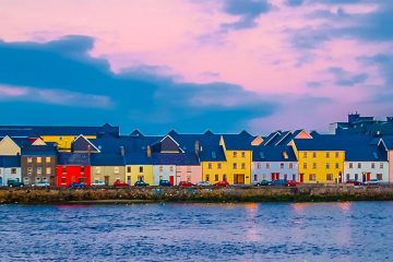 Pastel colored houses along the shore of Galway Harbor.
