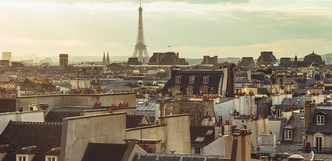 A view of the tops of buildings with the Eiffel Tower in the distance.