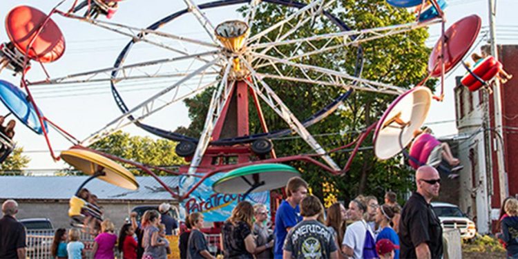 Circular carnival ride with people milling about below.