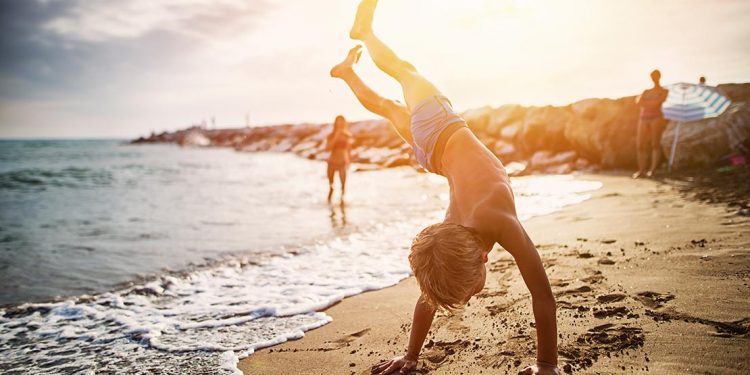 Child doing a handstand on the beach