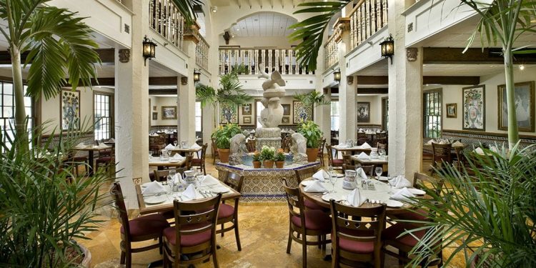 A white dining room at a restaurant with a fountain in the middle.