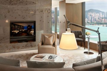 A sitting room in one of the suites at the Hotel ICON featuring a crescent couch and fireplace.