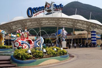 The entrance to Ocean Park with a white dome and fountain with fish statues.