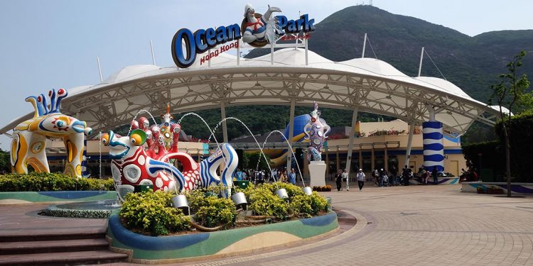 The entrance to Ocean Park with a white dome and fountain with fish statues.
