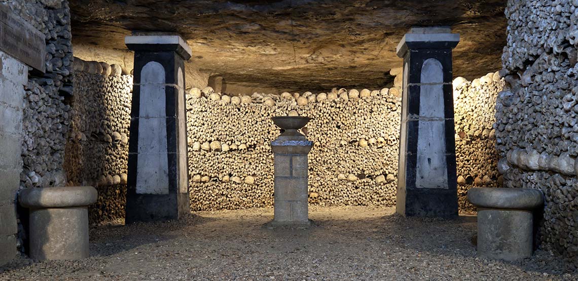 underground walls lined with human bones in the Paris catacombs