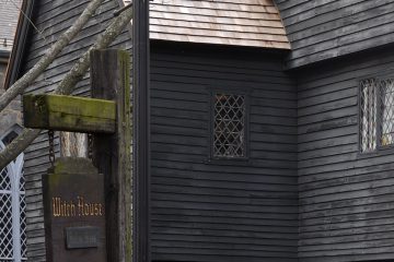 Brown wood siding on house with sign saying Witch House