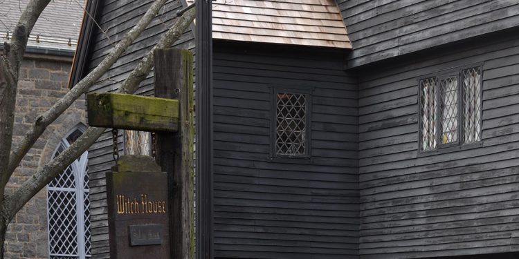Brown wood siding on house with sign saying Witch House