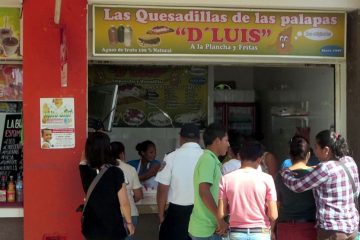 A food vendor in an outdoor food court selling quesadillas.