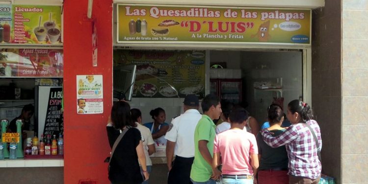 A food vendor in an outdoor food court selling quesadillas.