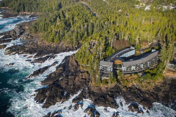 Overhead view of hotel along a rocky coast with frothing waters below.