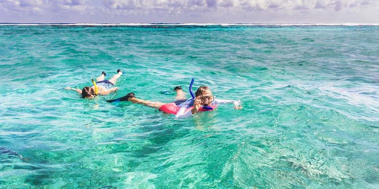 Two kids snorkeling in ocean.