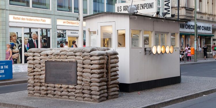 Small checkpoint building with sandbags in middle of street.