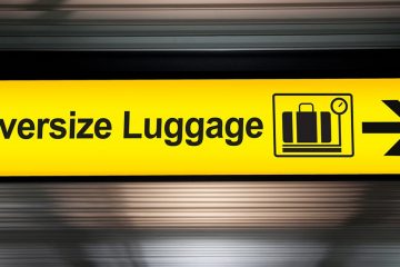 Sign at airport with arrow reading "Oversize Luggage"