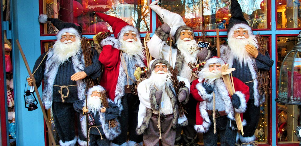 Santa Claus dolls outside a storefront.