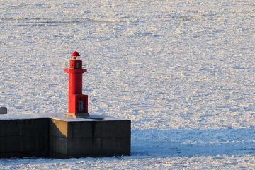 Red lighthouse and floating ice in The Sea of Okhotsk