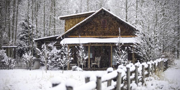 Cabin covered in snow.