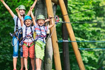 Kids standing on platform getting ready to zipline.