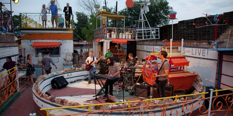 Circular stage with people up on platforms at Orange Show