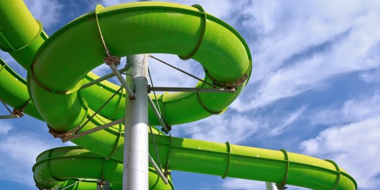 Green water park pipes against a blue sky