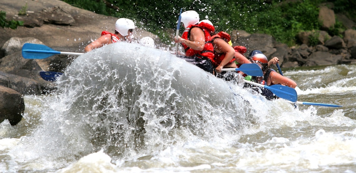 Boatload of rafters splashing through rapids on the New River