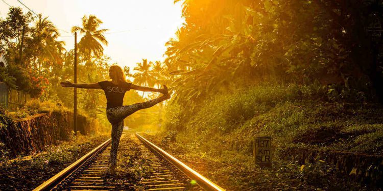 Sunrise yoga practise on train track in tropical sri lanka.