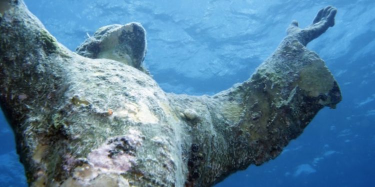 This is a close-up photo of the thirty-foot statue in John Pennekamp Coral Reef State Park in Florida of the Christ of the Abyss statue. It is a replica of a statue that is in the Mediterranean Sea.