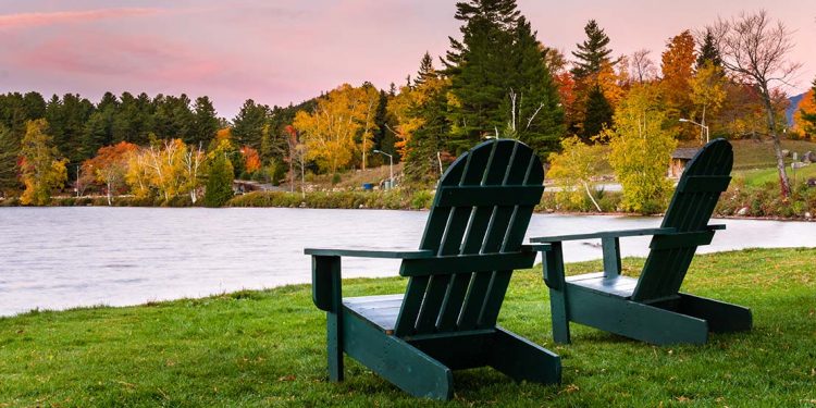 Two Adirondack chairs on Lake Placid in the fall.