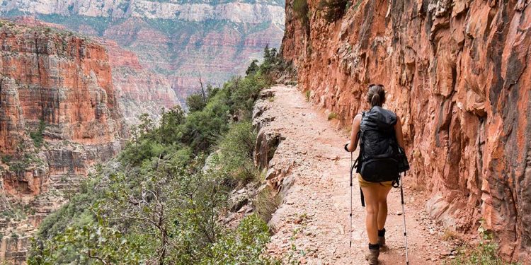 Woman hiking on narrow trail in Grand Canyon