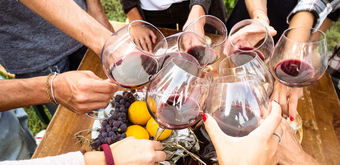People holding wine glasses in circle.