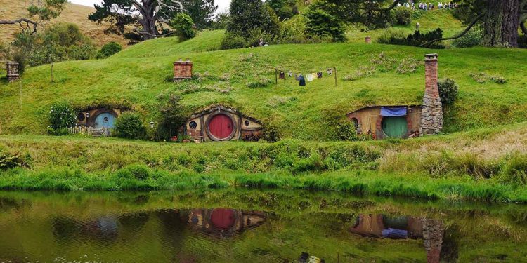 Thre hobbit holes in hillside in Hobbiton