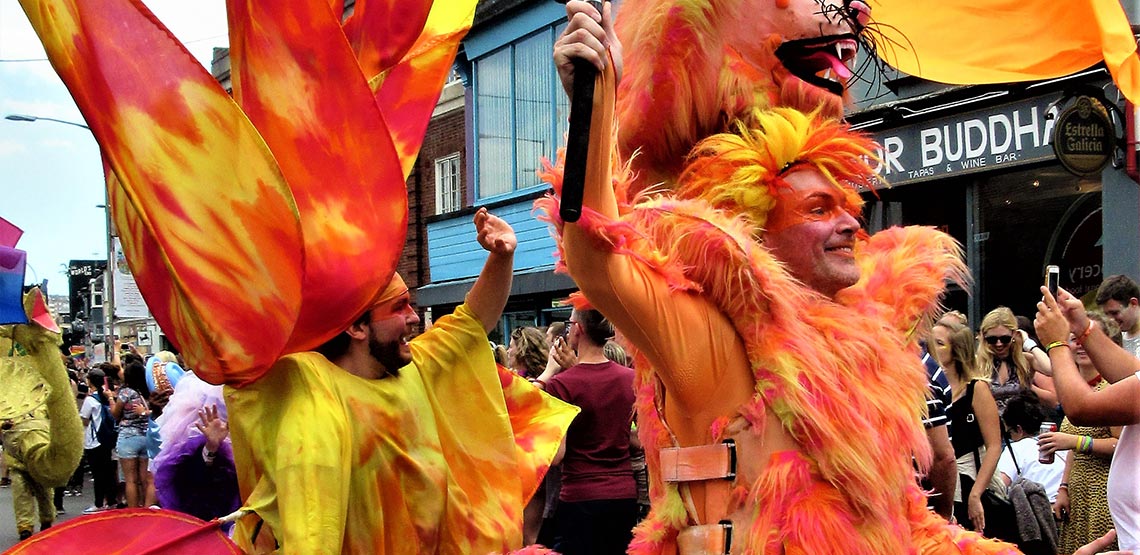 Men dressed in orange and yellow costumes in Gay Pride parade