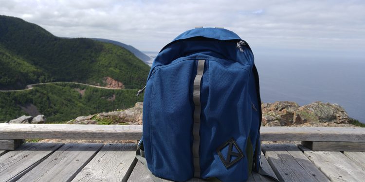 Backpack sitting on boardwalk with Cabot Trail in background