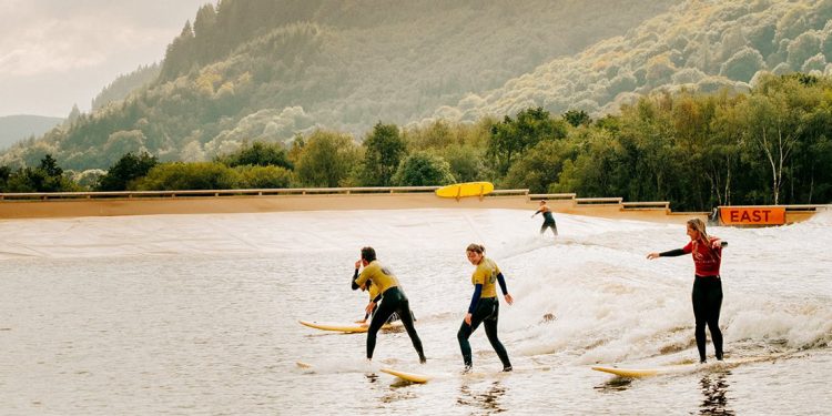 Four people surfing on man made lake